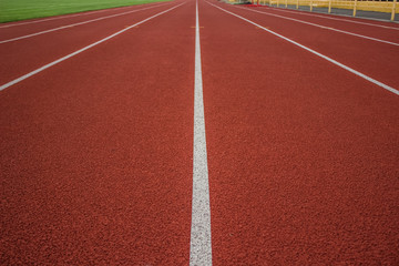 red running track background texture with white marking lanes and empty space for copy or text