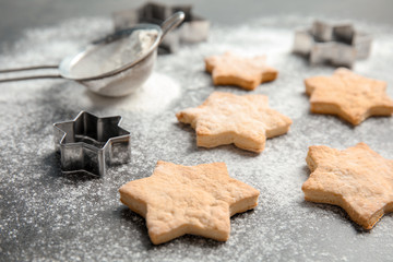 Tasty homemade Christmas cookies and flour on table
