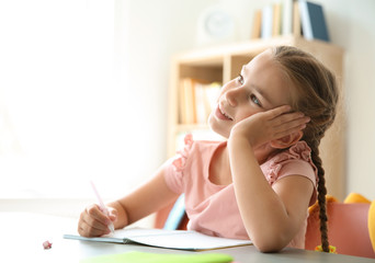 Obraz na płótnie Canvas Cute little child daydreaming at desk in classroom. Elementary school