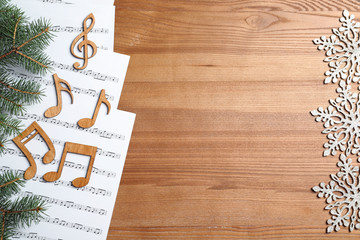 Flat lay composition with music sheets and notes on wooden background. Christmas songs concept
