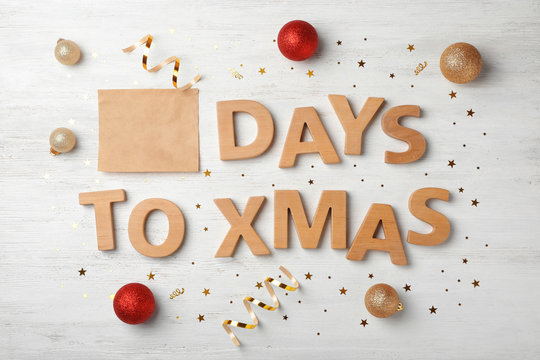 Flat lay composition with words DAYS TO XMAS and holiday decor on wooden background. Christmas countdown