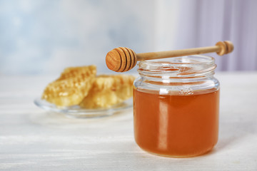 Jar of honey and dipper on table