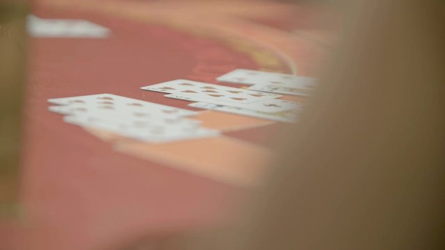 Slow motion shot of cards and chips on velvet poker table in casino. Gambling, luck and addiction concept.