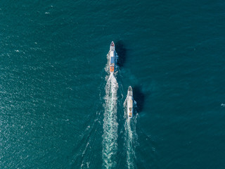 top view of two cruise ships in the open sea, one outrunning another