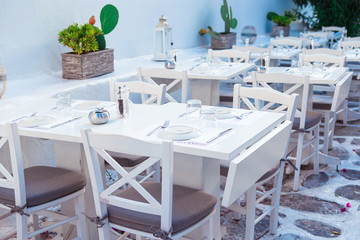 White tables with chairs at summer empty open air cafe