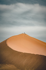 Sand dunes under blue sky. Sahara Desert, Previously, village houses transferred due to sands...