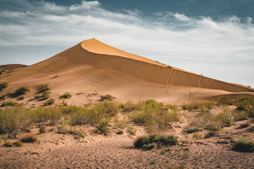 Fototapeta na wymiar Sand dunes under blue sky. Sahara Desert, Previously, village houses transferred due to sands movement.