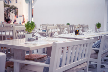 White tables with chairs at summer empty open air cafe