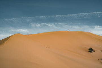 Sand dunes under blue sky. Sahara Desert, Previously, village houses transferred due to sands...