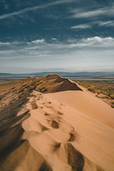 Sand dunes under blue sky. Sahara Desert, Previously, village houses transferred due to sands...