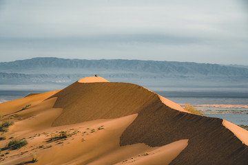 Sand dunes under blue sky. Sahara Desert, Previously, village houses transferred due to sands...