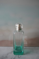 Obraz na płótnie Canvas Glasflasche, Flasche, Parfümflasche vor pastellfarbenem Hintergrund 