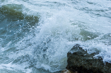 Fototapeta premium pebble stones on the sea beach, the rolling waves of the sea with foam