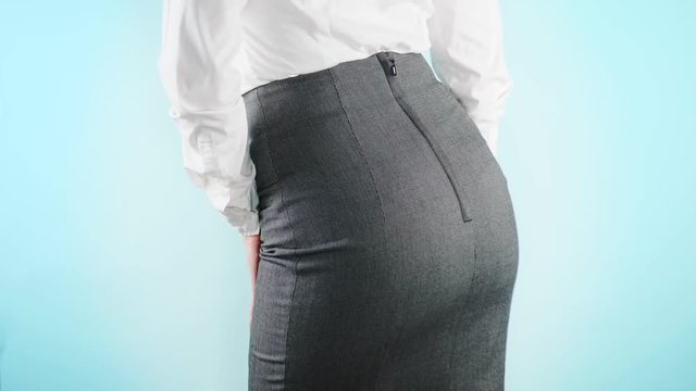 Beautiful business woman on a colored background. close-up skirt. dress code, move the hips. 4k, slow motion
