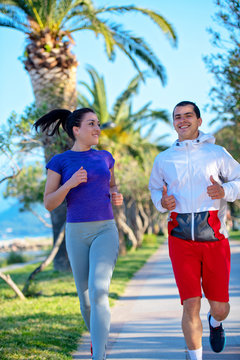 Urban sports, healthy young couple jogging in the city at sunny morning