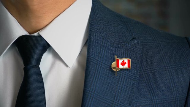 Businessman Walking Towards Camera With Country Flag Pin - Canada
