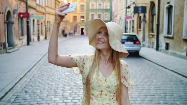 Woman taking selfie on square. Attractive woman posing for selfie and standing on city square.