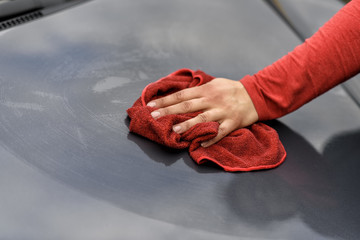 Ein Auto wird nach der Autowäsche mit einem Tuch poliert