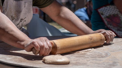 Cooking Process Of Armenian Bread Lavash. Baker Kneading Dough With Rolling Pin. Close up.