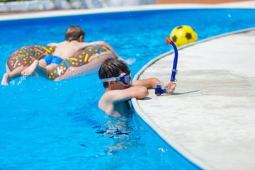 cute sporty boy swims in the pool with mask and has fun, smiles. vacation with kids, holidays, active weekends concept