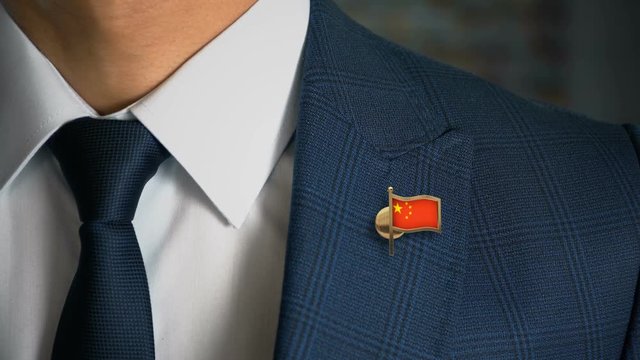 Businessman Walking Towards Camera With Country Flag Pin - China