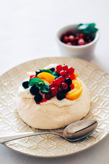 Tasty Pavlova dessert with white meringue, cream and fruit