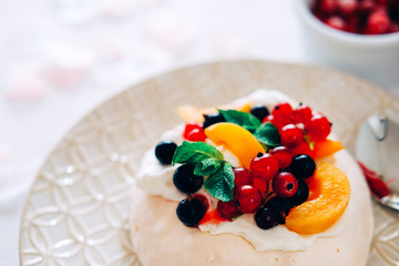Tasty Pavlova dessert with white meringue, cream and fruit