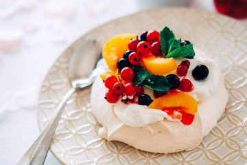 Tasty Pavlova dessert with white meringue, cream and fruit