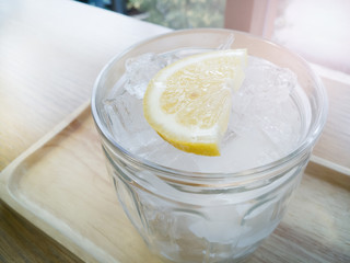 The ice lemon soda on wood table window light for background.