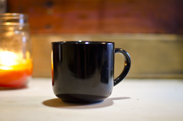 A solo blank black coffee mug on the old workshop bench. 