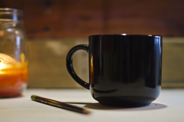 A blank black coffee mug on the tool bench getting ready to take on the tasks