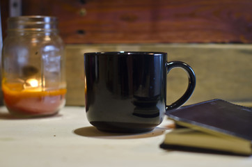 A blank black coffee mug on the workshop table next to the task list. 