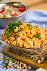 Indian chickpea salad with grated carrot, onion, garlic paste, tahini sesame seeds paste and fresh green herbs. Vegan, vegetarian healthy food.