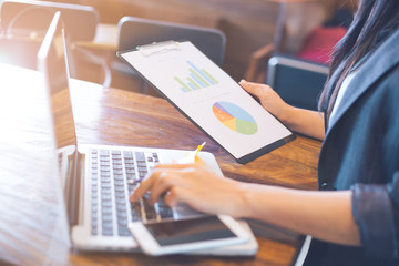 Business woman working with laptops and analysis charts and graphs showing results.