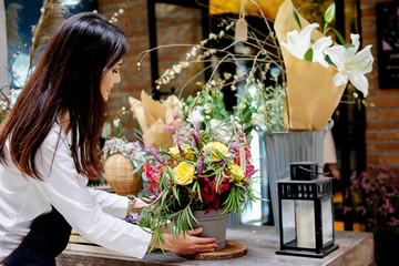 Cheerful charming young business owner flower shop store florist standing and holding flowers