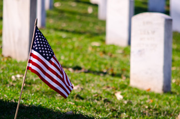 American flag in the foreground of military graves.