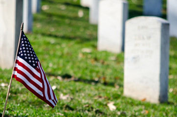 American flag in the foreground of military graves.