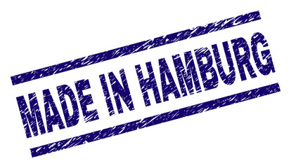 MADE IN HAMBURG stamp seal watermark with distress style. Blue vector rubber print of MADE IN HAMBURG caption with retro texture. Text caption is placed between parallel lines.