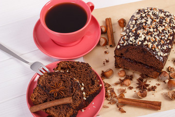 Dark cake with chocolate, cocoa and plum jam, cup of coffee, delicious dessert concept