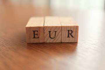 EUR (Euro) Text Block on Wooden Table