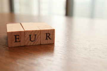 EUR (Euro) Text Block on Wooden Table