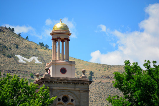 Colorado School of Mines Guggenheim Hall tower on a sunny day with a large letter M on the mountains in the background