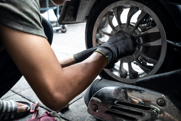 Fototapeta na wymiar The Motorcycle change tire by Man repairer at Bangkok Thailand.