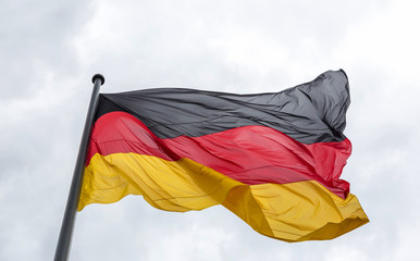 The national flag of the Federal Republic of Germany has evolved in the wind against the sky