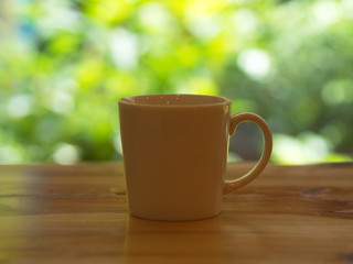 Closeup White Cofee Cup  with Green leaf bokeh.