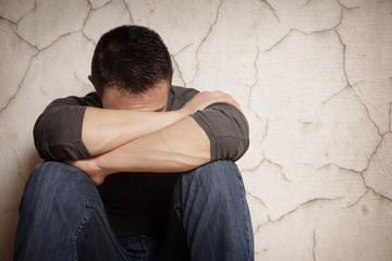 depression devastated young man hiding his face                               