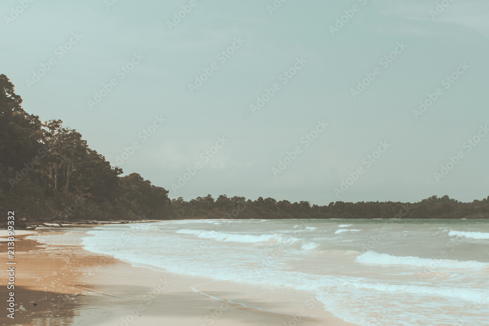 Wall mural vintage photo of beautiful beach landscape with cloudy sky and sea with waves.