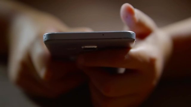 human is browsing in internet using high-technology mobile phone, holding it in hands