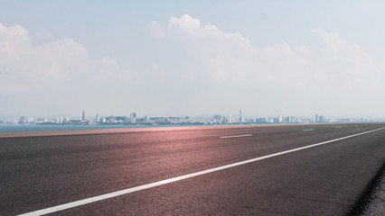 Fototapeta premium Empty road asphalt with panoramic cityscape