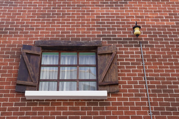 Open old window on brick wall.